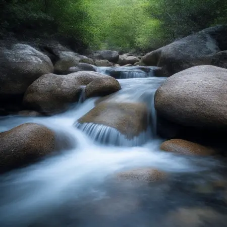 Smooth river stones with gently flowing water, symbolizing harmony and balanced energy